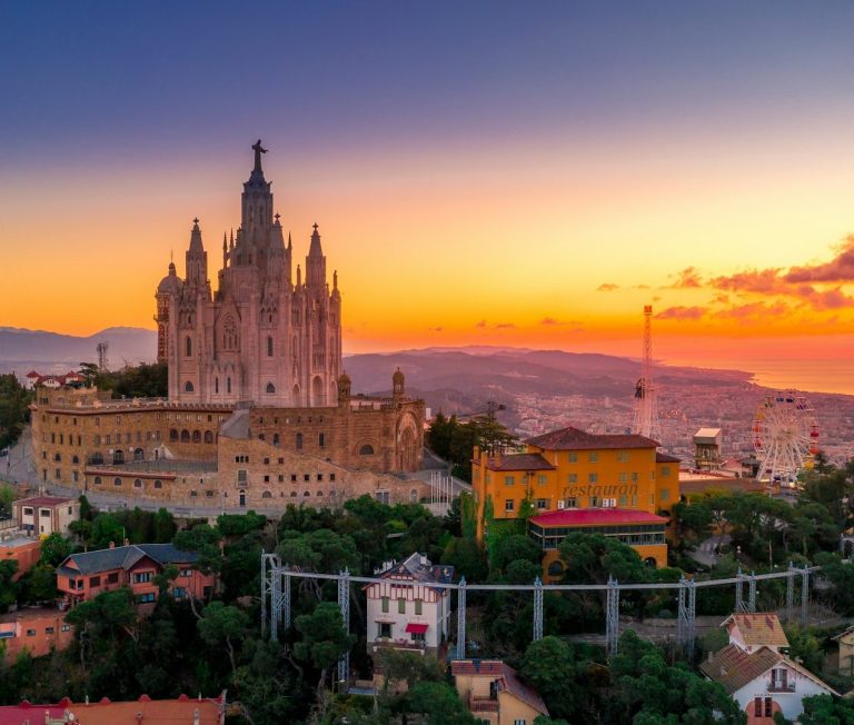 Barcelone Vue du château de Montjuïc au coucher du soleil, avec des bâtiments colorés en foreground.